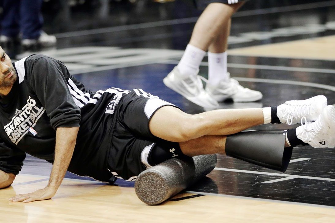 Foam rolling a leg on the court, a must-have recovery gift for athletes.