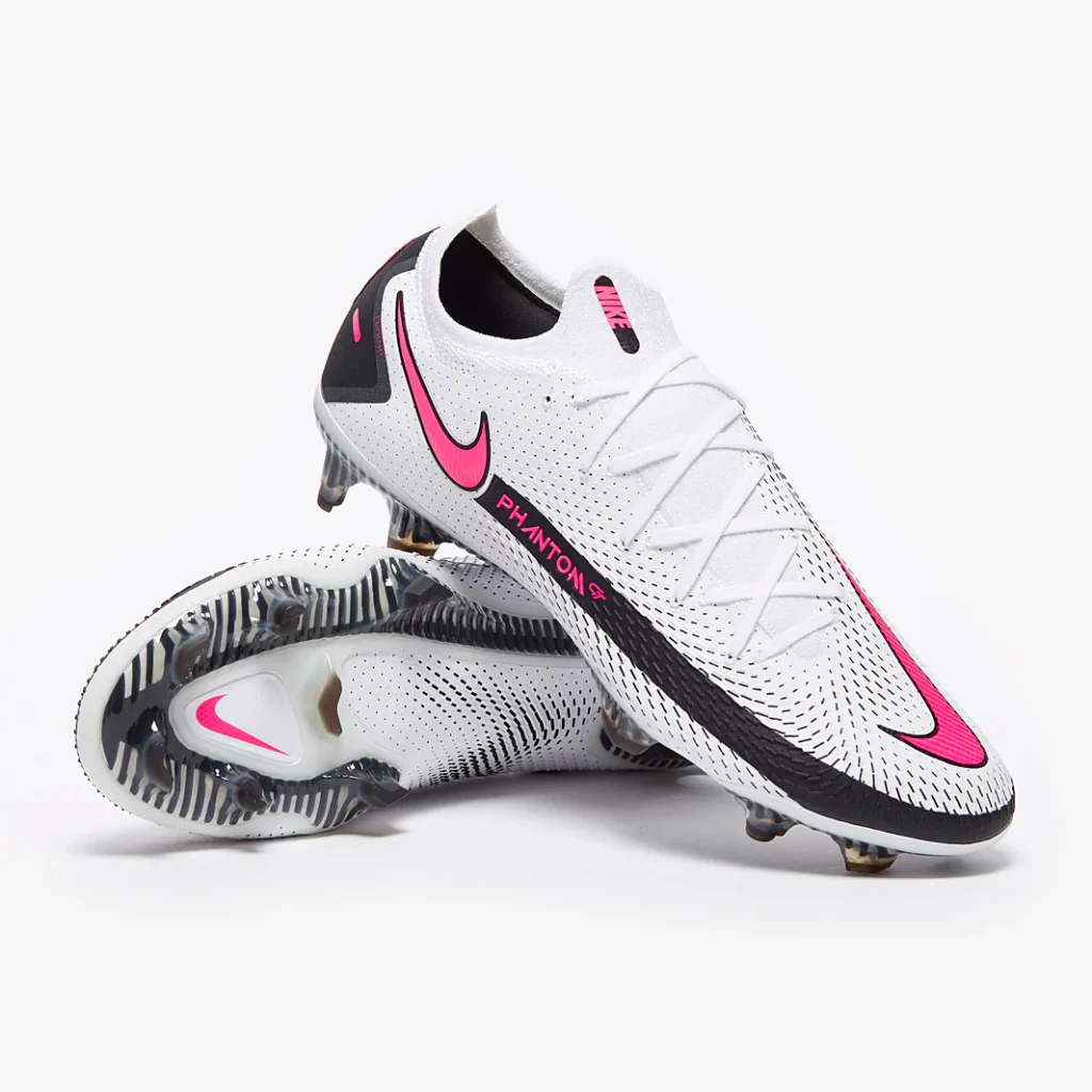 White Nike Phantom Elite boots with bold pink swoosh accents and a raised texture across the upper.