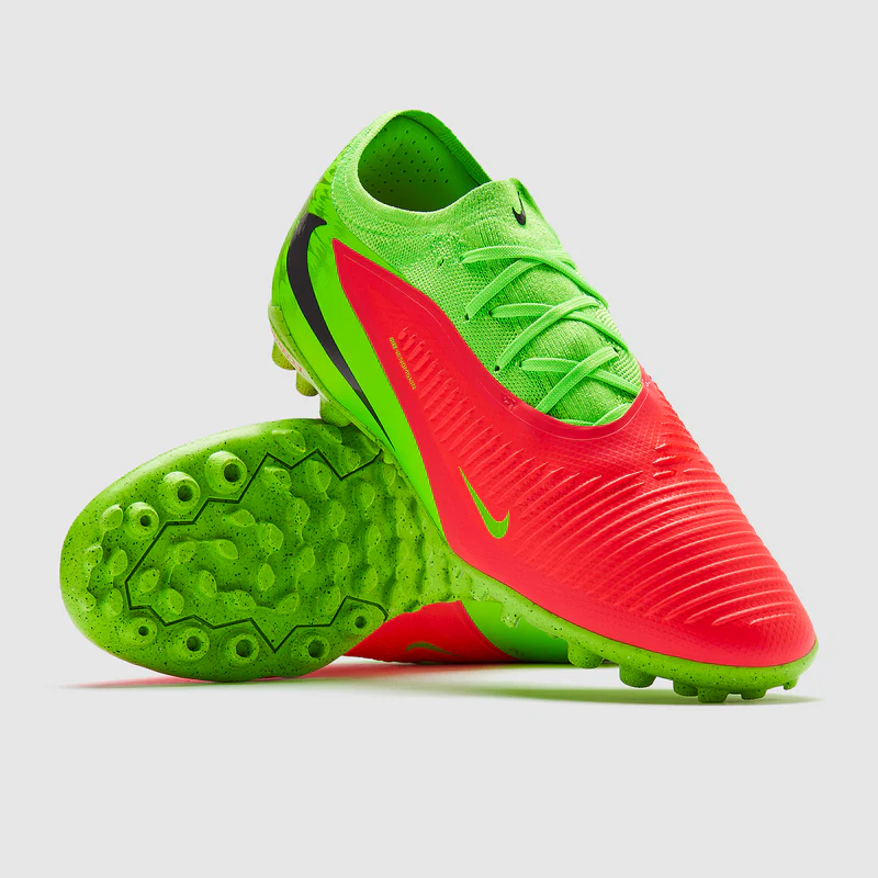 Brightly colored turf-specific soccer shoes featuring a multi-lug rubber traction pattern.